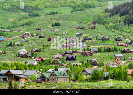 Mount Crested Butte Dorf Stadt im Sommer mit bunten Gras und viele Holz- Unterbringung Häuser auf den Hügeln mit grünen üppigen Farbe Stockfoto