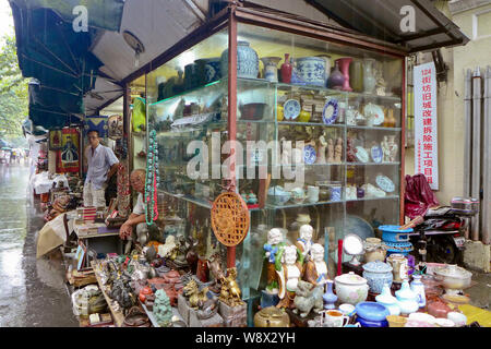 Die chinesischen Anbieter warten in ihren Geschäften an der Shanghai Dongtai Road Antique Market in Shanghai, China, 18. August 2014. Ein Antiquitäten Street Market Population Stockfoto