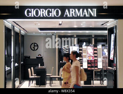 ---- Fußgänger vorbei ein Giorgio Armani store in Nanjing City, East China Jiangsu Provinz, den 8. August 2013. Italienische Luxusartikel Marke Armani Stockfoto