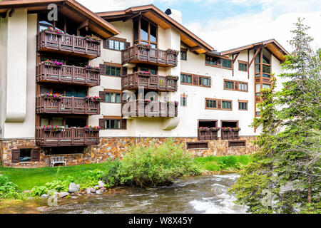 Vail, USA - 29. Juni 2019: Europäische Swiss Style resort Town Apartment Gebäude Balkon außen mit Blumenschmuck in Colorado von Gore Creek Rive Stockfoto