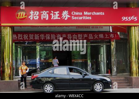 ---- Ein Kunde geht auf eine Filiale der China Merchants Wertpapiere in Yichang City, Central China Provinz Hubei, 17. Juli 2013. China Merch Stockfoto