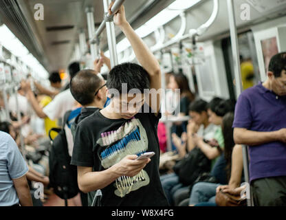 Ein Passagier schaut auf sein Mobiltelefon in einer U-Bahn in Shanghai, China, 11. Juni 2014. Diese Fotos wurden von einem ausländischen Fotografen, der uns genommen Stockfoto