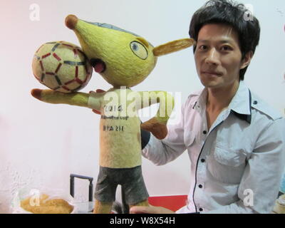 Chinesische hairstylist Huang Xin stellt mit seinem Haar - Fuleco, das Maskottchen der FIFA WM 2014 in Brasilien, in Peking, China, 8. Mai 2014. Ein Chines Stockfoto