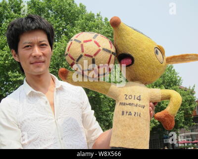 Chinesische hairstylist Huang Xin stellt mit seinem Haar - Fuleco, das Maskottchen der FIFA WM 2014 in Brasilien, in Peking, China, 8. Mai 2014. Ein Chines Stockfoto