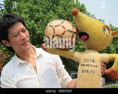 Chinesische hairstylist Huang Xin stellt mit seinem Haar - Fuleco, das Maskottchen der FIFA WM 2014 in Brasilien, in Peking, China, 8. Mai 2014. Ein Chines Stockfoto