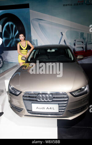---- Ein Modell wirft mit einem Audi A 4 L Auto während eines Auto Show in Jinan City, East China Provinz Shandong, 13. September 2014. Sobald die Lieblings b Stockfoto