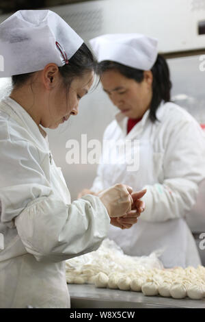 Chinesische Mitarbeiter machen sie Kleine gedämpfte Brötchen an einem Shanshan gedämpft Knödel Restaurant einer Kette in Shanghai, China, 19. März 2014. Stockfoto