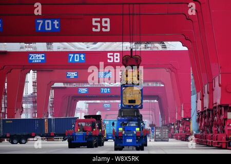 ------ Kran Fahrzeug Entladen eines Containers in fremde Länder von einem Lkw exportiert im Hafen von Qingdao, in Qingdao, in der ostchinesischen Provinz Shandong Stockfoto