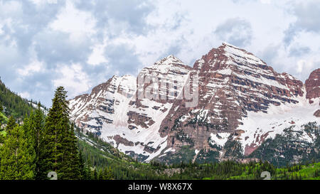 Maroon Bells closeup in Aspen, Colorado während der Blauen Stunde bewölkt Morgen vor Sonnenaufgang mit Rocky Mountain Peak und Schnee im Frühsommer Stockfoto