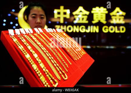 ---- Eine chinesische Angestellte zeigt Gold Halsketten in einem Geschäft von Zhongjin Gold in Qingdao Stadt, East China Provinz Shandong, 1. Juni 2014. China's larges Stockfoto