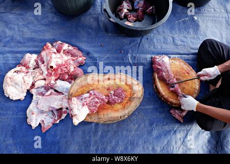 Oberwinkelaufnahme der Hände, die das Kuhfleisch hacken. Stockfoto