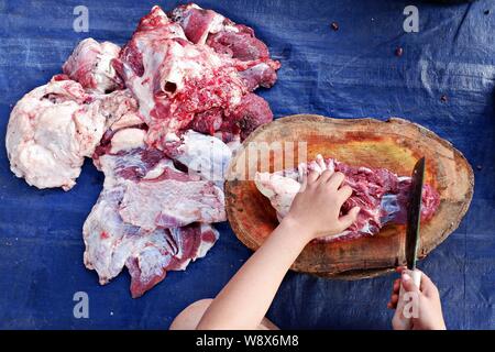 Oberwinkelaufnahme der Hände, die das Kuhfleisch hacken. Stockfoto