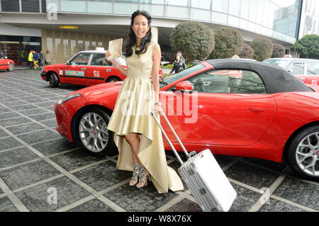 Hong Kong Sängerin und Schauspielerin Karen Mok stellt mit einem Koffer, wie sie für eine Pressekonferenz kommt für ihr neues Album "anfallenden gehaltsbezogenen" in Hongkong, Stockfoto