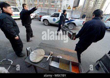 ------ Chinesische Offiziere von der Beijing Municipal Bureau der Stadt Verwaltung und Rechtsdurchsetzung ein Grill an einem strassenrand Grill konfiszieren Abschaltdruck Stockfoto