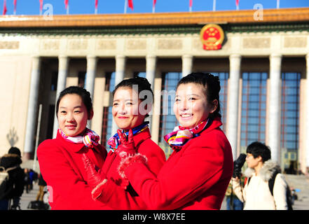 Chinesische Hostessen in rote Uniformen posieren für Fotos vor der Eröffnung der zweiten Tagung des 12. NPC (Nationale Völker Congres Stockfoto