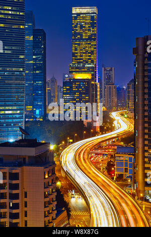 Nachtansicht der Yan'an Road Hochstraße neben dem Jing An Hotel Shangri-la, am höchsten, und andere Hochhäuser in der Innenstadt von Shanghai, Kinn Stockfoto