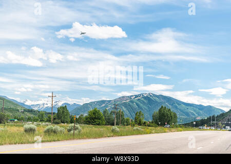 Basalt, USA - 29. Juni 2019: Straße Autobahn Straße 82 nach Aspen, Colorado Stadt mit Autos im Verkehr und Gebirge und Flugzeug fliegen Stockfoto