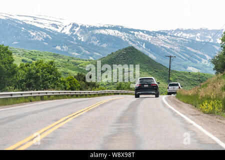 Aspen, USA - 29. Juni 2019: Brush Creek Road street in Snowmass Village, Colorado Stadt mit Autos im Verkehr und Gebirge Stockfoto