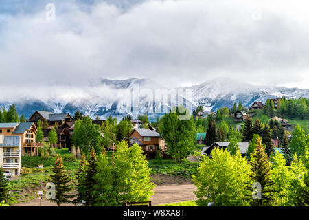 Mount Crested Butte, USA Colorado Dorf im Sommer mit bewölkt Nebel Nebel Sonnenaufgang morgen und Häuser auf Hügeln mit grünen Bäumen, Stockfoto