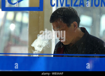 --FILE - Ein chinesischer Mann raucht eine Zigarette auf einem Bahnhof in der Stadt Shuangyashan, im Nordosten der chinesischen Provinz Heilongjiang, 19. September 2012. Chin Stockfoto