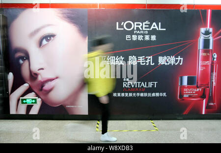 ---- Einen Fußgänger an einer Werbung für LOreal Paris Kosmetik und Hautpflege Produkte in Schanghai, China, 18. Dezember 2013. Französische cosme Stockfoto