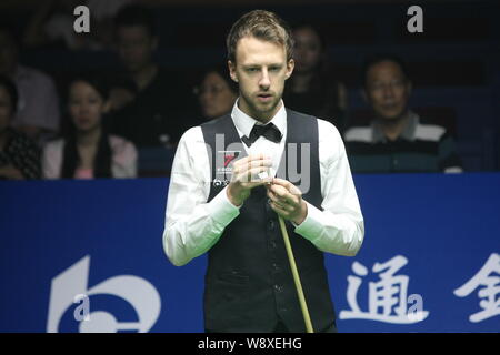 Judd Trump von England Kreiden seine Cue als hält er einen Schuß gegen Dominic Dale von Wales während der ersten Runde der 2014 World Snooker Sha Stockfoto