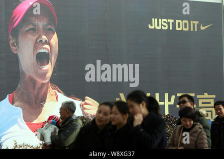 Fußgänger vorbei eine Werbung von Nike mit dem Porträt des Chinesischen Tennis star Li Na in Shanghai, China, 26. Januar 2014. Li Na ist werden. Stockfoto