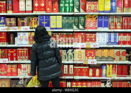 ---- Ein Kunde Geschäfte für baijiu oder destilliertem Alkohol in einem Supermarkt in Shanghai, China, 25. Februar 2014. So wie Russland hat seine Wodka, Mexiko Stockfoto