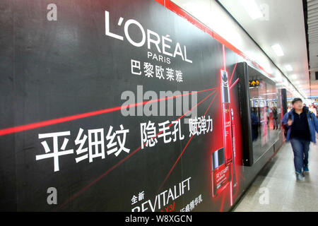 ---- Fußgänger vorbei an einer Werbung für LOreal Paris Kosmetik und Hautpflege Produkte in Schanghai, China, 18. Dezember 2013. Französische cosmeti Stockfoto