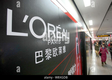 ---- Fußgänger vorbei an einer Werbung für LOreal Paris Kosmetik und Hautpflege Produkte in Schanghai, China, 18. Dezember 2013. Französische cosmeti Stockfoto