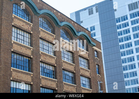 Ein Steingebäude aus dem frühen 20. Jahrhundert steht in contast mit einem modernen Konzept Hotel in einem historischen Viertel, die nie aufhört zu wachsen. Stockfoto