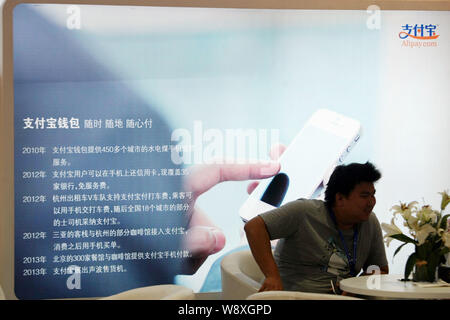 ------ Sitzt ein Besucher am Stand von Alipay.com von Alibaba Group während einer Ausstellung in Shanghai, China, 16. September 2013. Chinesische Käufer können Stockfoto