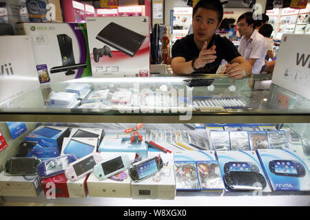 ---- Ein Verkäufer verkauft Sony PS3, PSVita, PSP, Microsoft Xbox 360, Nintendo Wii und 3 DS Spielkonsolen in einem Stall in einem digitalen Produkte Mall in Shangh Stockfoto