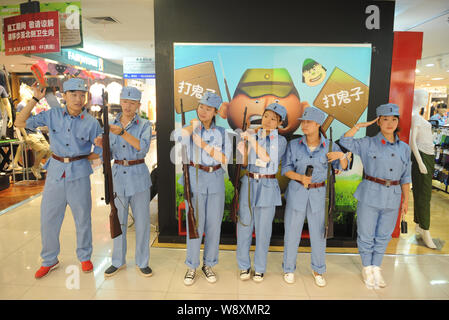 Chinesische Beamte in blauen Uniformen des 8. Route Armee Line up während einer Werbekampagne in einer Shopping Mall in Changchun Stadt gekleidet, North China Stockfoto