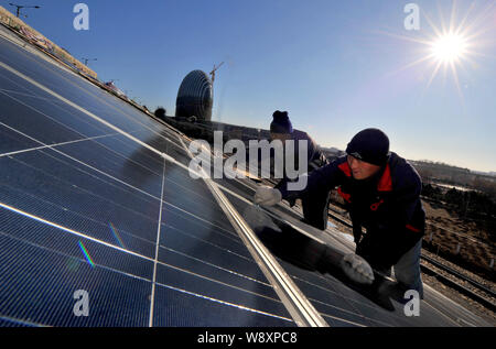 ------ Chinesische Arbeiter installieren Solaranlagen mit einer Photovoltaik- Kraftwerk in Peking, China, 14. Dezember 2013. China, der weltweit größte Solar Stockfoto