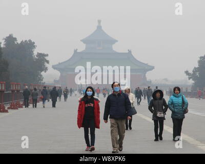 Besucher tragen Gesichtsmasken Spaziergang im Tempel des Himmels in schweren Smog in Peking, China, 23. Februar 2014. Peking warf die citys Ai Stockfoto