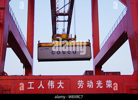 ------ Kran Fahrzeug entlädt einen Behälter mit cosco am Hafen in Rizhao Rizhao City, East China Provinz Shandong, 5. April 2014. Zwei von China Stockfoto