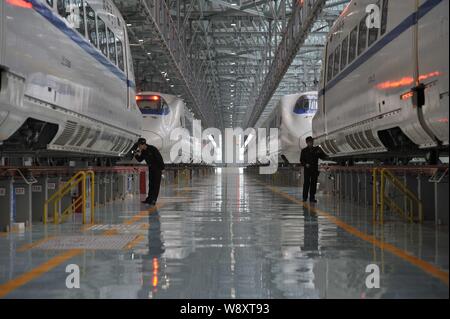 Chinesische Techniker untersuchen CRH (China Railway High speed) bullet Züge von Guiguang (Guiyang-Guangzhou) High-Speed Rail Line in der Maintenance Station Stockfoto