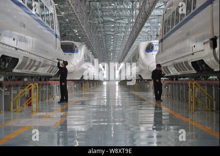 Chinesische Techniker untersuchen CRH (China Railway High speed) bullet Züge von Guiguang (Guiyang-Guangzhou) High-Speed Rail Line in der Maintenance Station Stockfoto