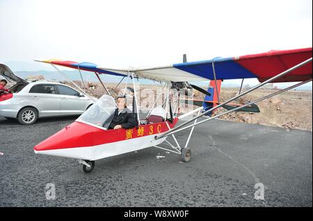 Pensionierte chinesischen Arzt Jin Shaozhi sitzt in seinem chinesischen Honigbiene-3C super leichtes Flugzeug auf einer Autobahn im Bau in Jinyun County, Lishui cit Stockfoto