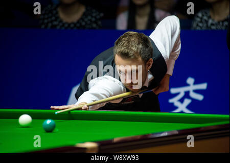 Judd Trump von England spielt einen Schuß gegen Dominic Dale von Wales während der ersten Runde der 2014 World Snooker Shanghai Masters in Shanghai. Stockfoto