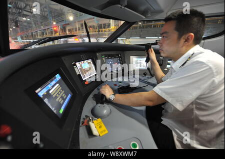 Ein Treiber ist dargestellt im Cockpit eines CRH (China Railway High speed) Bullet Zug bei der Maintenance Station in Chongqing, China, 26. Juni 2014. Chi Stockfoto