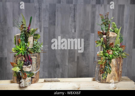 Blumenschmuck der mehrfarbigen Blüten, Blätter und Beeren in Holz- stumpf. Künstliche Blumen Stockfoto