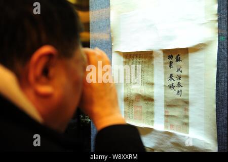 Ein Besucher sieht genau auf ein High Definition Print der angeblich authentische Gong Fu Tie Kalligraphie von alten chinesischen Schriftsteller und kalligraph Su Stockfoto