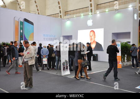 ---- Besucher vorbei an einer Werbung für iPhone 6 und iPHone 6 Plus Smartphones am Stand von Apple bei der China Mobile Ausstellung Shenya Stockfoto