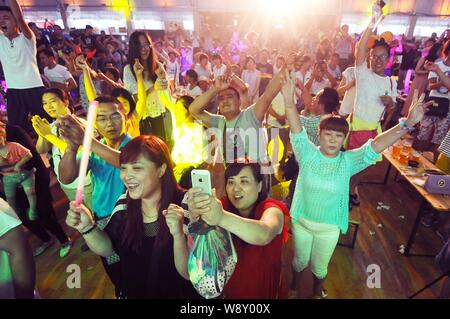 Die Menschen jubeln, wie sie Bier im 24. Qingdao International Beer Festival in Qingdao Stadt, East China Provinz Shandong, 20. August 2014 genießen. Stockfoto