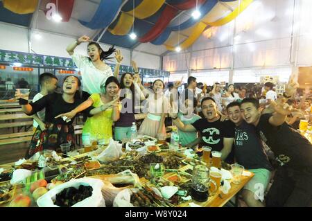 Die Menschen jubeln, wie sie Bier und andere Lebensmittel im 24. Qingdao International Beer Festival in Qingdao Stadt, East China Provinz Shandong, 20 genießen Stockfoto