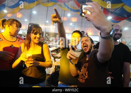 Die Menschen jubeln, wie sie Bier und andere Lebensmittel im 24. Qingdao International Beer Festival in Qingdao Stadt, East China Provinz Shandong, 20 genießen Stockfoto