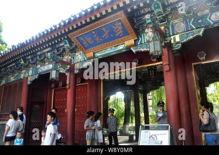 ---- Fußgänger für Fotos vor einem Tor der Peking Universität (PKU) in Peking, China, 17. August 2013 darstellen. China der renommierten Peking Unive Stockfoto