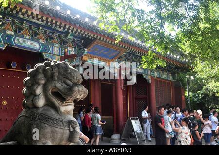 ---- Fußgänger für Fotos vor einem Tor der Peking Universität (PKU) in Peking, China, 17. August 2013 darstellen. China der renommierten Peking Unive Stockfoto